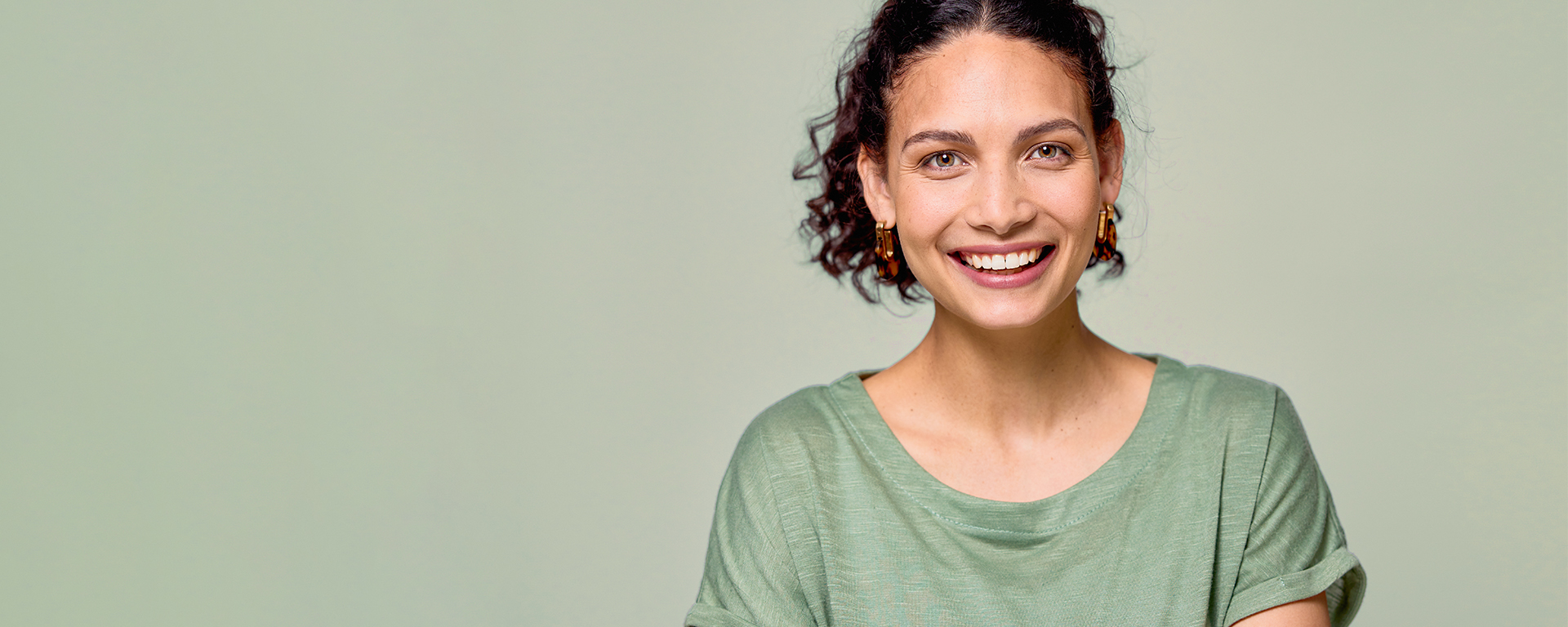 Eine Frau lächelt vor grünem Hintergrund