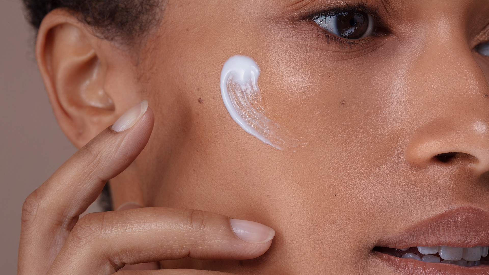 Close-Up von Gesicht mit Creme auf der Wange