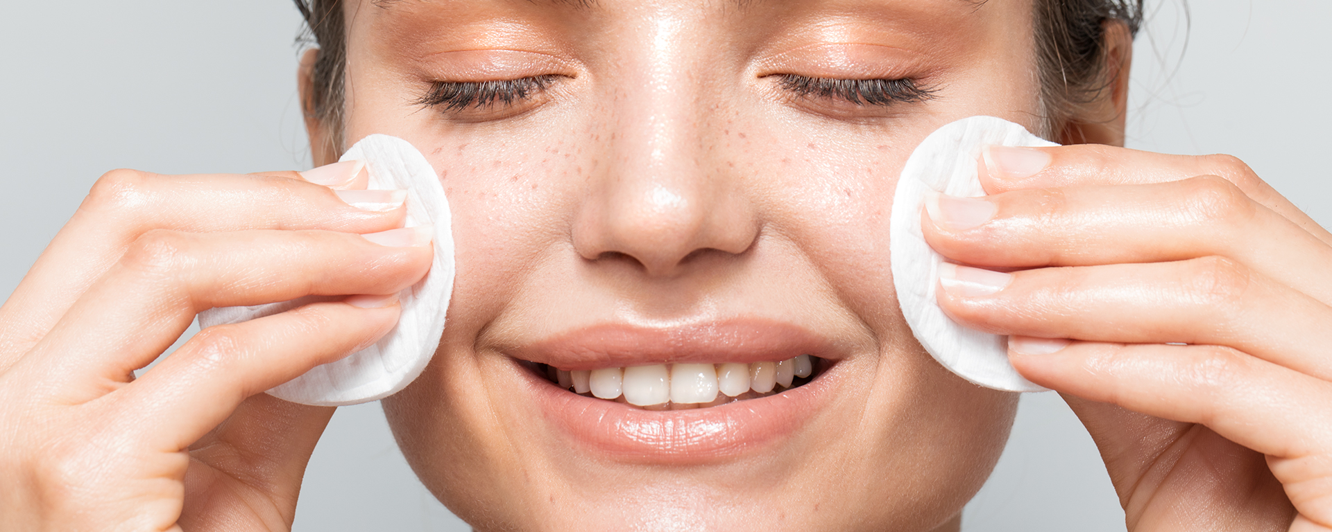 Frau reinigt ihr Gesicht mit Wattepads