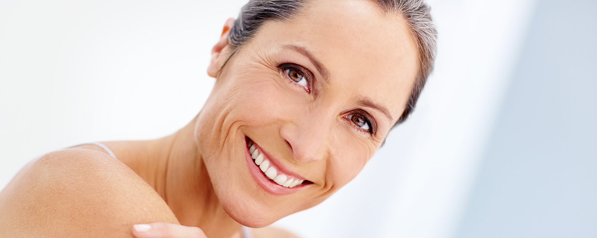 Lächelnde Frau mit reifer, gepflegter Haut